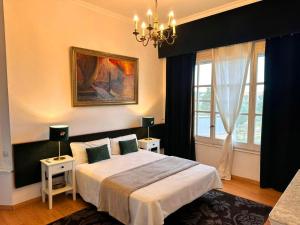 a bedroom with a bed and a chandelier at Villa COLONIAL in Vilaseca de Solcina