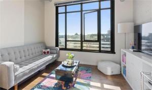 a living room with a couch and a large window at Downtown one bedroom apartment 2 in Victoria