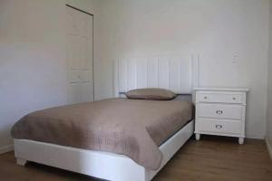 a small bedroom with a bed and a dresser at Downtown one bedroom apartment 2 in Victoria