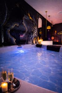 a hot tub in a room with candles and wine glasses at Love Room 85 avec Jacuzzi & Terrasse Privé in Kortrijk