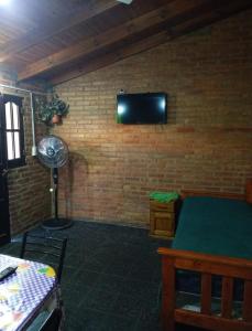 a room with a television on a brick wall at Mi Niña's in Villa Cura Brochero
