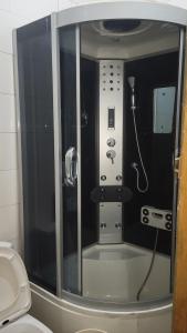 a bathroom with a shower with a phone in it at Lakatabu Apartments in Mama