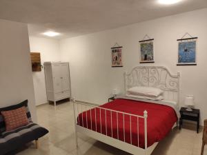 a bedroom with a bed with a red blanket at Vivienda LorenNani in El Paso