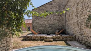 a stone building with a fire pit in a yard at Mas Labrugade in Lebreil