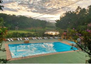 a large swimming pool with chairs and a lake at Chalé La Belle de Jour - Camping Carrion - 10 min Cacau Park - Itu -SP in Itu +38 photos