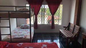 a bedroom with bunk beds and a bench and a window at Hotel las palmas in Rosa Zárate