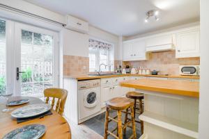 a kitchen with white cabinets and a table and chairs at 2 Bed in Peterstow oc-w33537 in Peterstow