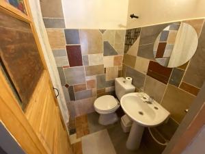 a small bathroom with a toilet and a sink at Hosteria La Pushka in Purmamarca
