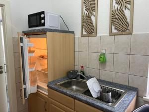 a small kitchen with a sink and a microwave at Pension Kaditz in Dresden
