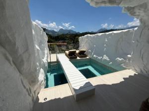 a house with a swimming pool in a rock wall at Pousada Apple House Paraty in Paraty