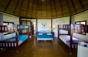 a bedroom with three bunk beds in a room at Hotel Oasis & Surf Camp in Santa Catalina