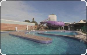 a swimming pool with a water slide in the middle at Denny's Holiday Homes in Blackpool