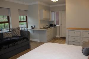a living room with a couch and a kitchen at The Fairways, CastleBlayney in Castleblayney