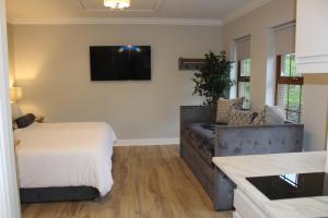 a living room with a couch and a tv on the wall at The Fairways, CastleBlayney in Castleblayney