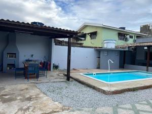 a backyard with a swimming pool and a house at Casa Familiar Ampla - Conforto e Lazer no Frances in Praia do Frances