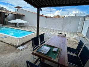 a patio with a table and a swimming pool at Casa Familiar Ampla - Conforto e Lazer no Frances in Praia do Frances