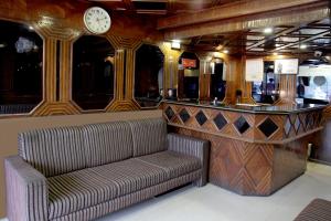 a bar in a train with a couch and a clock at Hotel Raj in Aurangabad