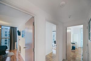 a white room with a hallway with a mirror at Hub Retreat in Milton Keynes