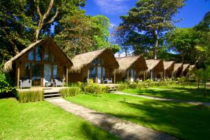 a resort with thatched huts in the grass at Hotel Oasis & Surf Camp in Santa Catalina