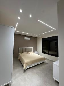 a bedroom with a bed and a flat screen tv at شاليه الدرة Durra Chalet in Amman