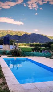 a blue swimming pool with mountains in the background at Mirabela Casa con vista panorámica a las sierras en Bialet Massé- Hasta 4 personas in Bialet Massé