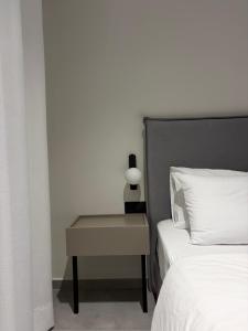 a bedroom with a bed and a table with a lamp at Bright 7th floor Studio-Near Center of Xanthi in Xanthi