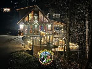 a large wooden house with lights on it at night at Wonderland Cabin in Sevierville