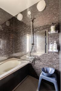 a bathroom with a tub and a toilet and a sink at Hakuba Powder Cottage in Hakuba +24 photos