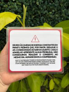 a person holding a sign in front of a plant at Studio Hashi 04 in Paraty