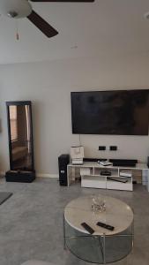 a living room with a large tv and a table at Furnished Private Room in Las Vegas