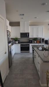 a kitchen with white cabinets and a stove top oven at Furnished Private Room in Las Vegas