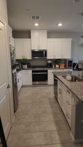 a kitchen with white cabinets and a counter top at Furnished Private Room in Las Vegas +7 photos