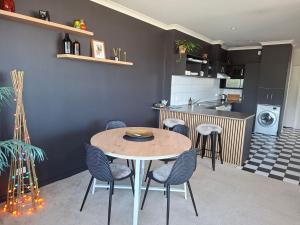 a kitchen with a table and chairs in a room at 2 Bed Apartment-Panoramic Views in Napier