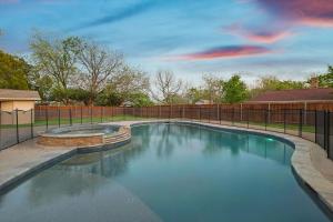 a swimming pool in a yard with a fence at Gorgeous 4BR Home with Huge Yard Pool in Denton