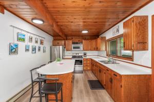 a kitchen with wooden cabinets and a white counter top at Tamarack Lodge Tomahawk WI in Lake Tomahawk