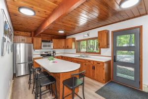 a kitchen with wooden cabinets and a table and chairs at Tamarack Lodge Tomahawk WI in Lake Tomahawk +21 photos