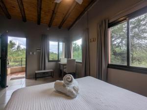 a bedroom with a bed with a towel on it at Posada Abrazo Serrano en Carpintería in Carpintería