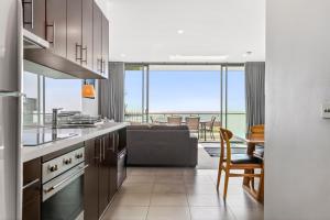 a kitchen and living room with a view of the ocean at The Dolphin Apartments in Apollo Bay