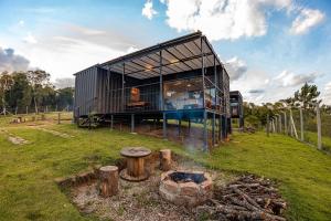 a black house with a fire in a field at Villa Container in the Wine Route in São Roque