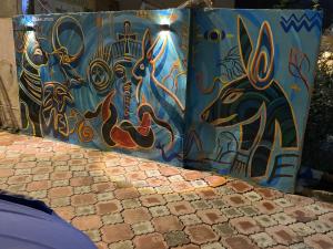 a wall covered in graffiti with a painting on it at Farida Pyramid Boutique Hotel in Cairo