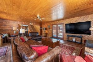 a living room with a leather couch and a flat screen tv at Grace Place in Watersmeet +19 photos