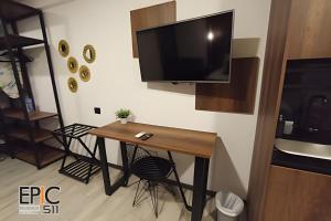 a room with a table and a television on a wall at Epic Suite 511 Premium Airport in Pereira