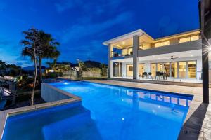 a swimming pool in front of a house at night at Maison De Vacances in Banksia Beach