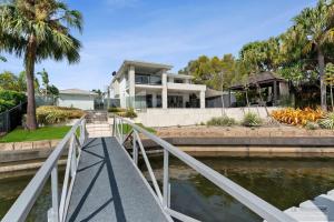 a house with a bridge over a body of water at Maison De Vacances in Banksia Beach