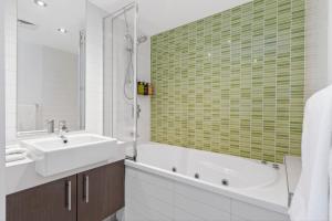 a bathroom with a tub and a sink and a bath tub at The Dolphin Apartments in Apollo Bay +96 photos