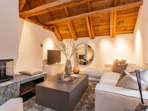 a living room with white furniture and wooden ceilings at Villa Filzer in Kirchberg in Tirol