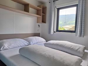two beds in a room with a window at Mobile Home in Austrian Countryside in Altossiach