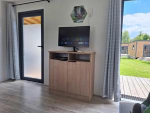 a living room with a television on a wooden cabinet at Mobile Home in Austrian Countryside in Altossiach