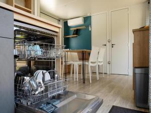 a kitchen with a dishwasher with dishes in it at Mobile Home in Austrian Countryside in Altossiach