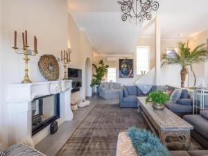 a living room with blue couches and a fireplace at Private Bedroom in a Luxurious Villa, Budens in Budens